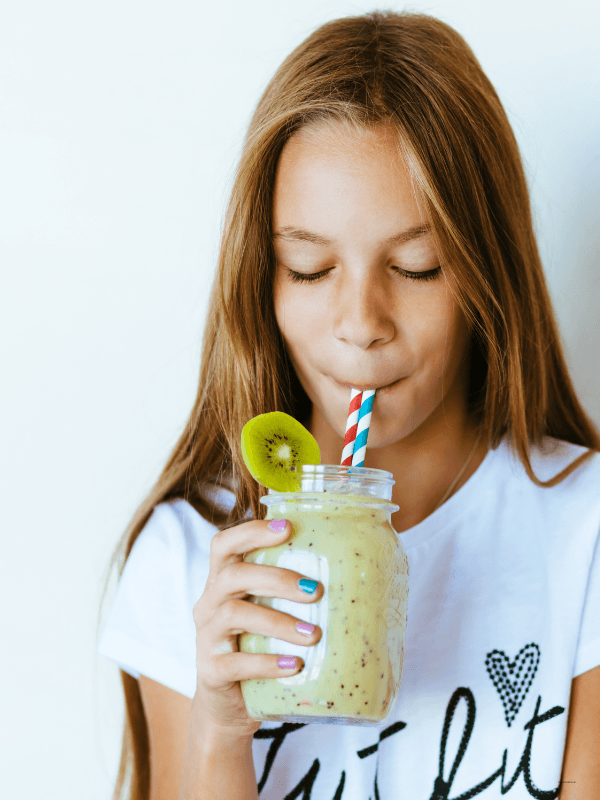 girl drinking a smoothie with kids vitamins